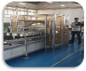 Busduct automatic packing machine side view showing PLC control panel and film wrapping mechanism